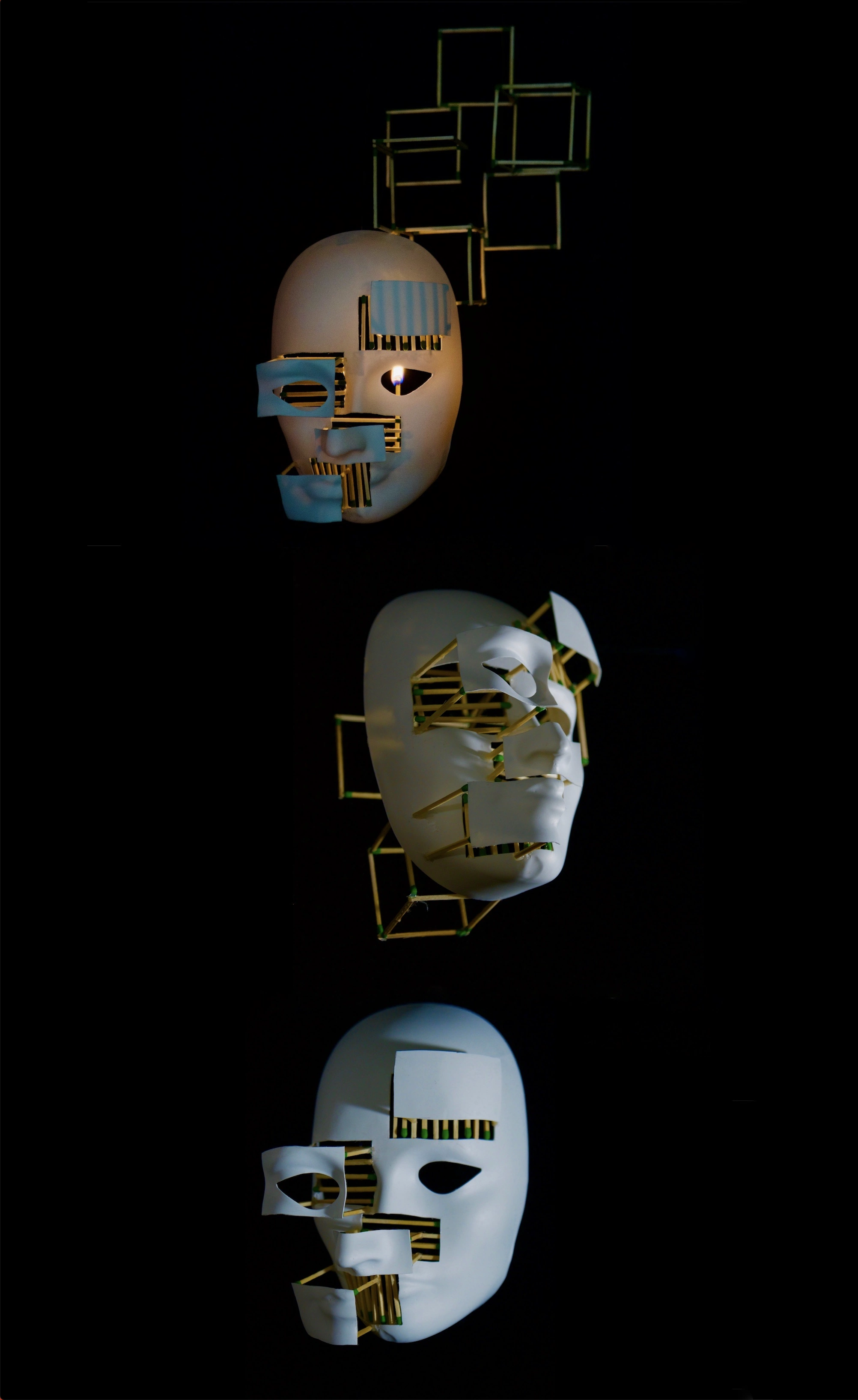 Three masks suspended in fragile structures of wooden matches against black.